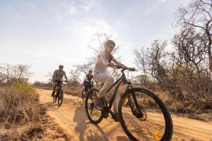 a group of people riding bikes on a dirt road at Palala River Cottages in Vaalwater