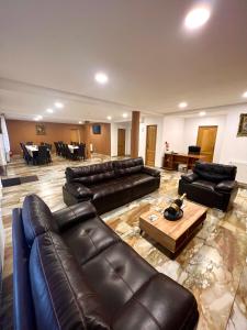 a large living room with leather furniture and a table at Caesars HOUSE Lac Belis in Luna de Sus