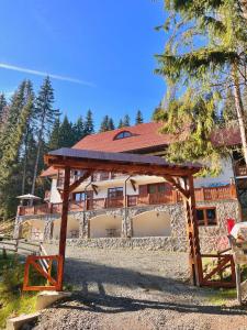 a large house with a wooden pavilion in front of it at Caesars HOUSE Lac Belis in Luna de Sus