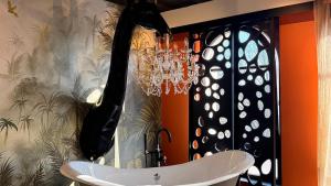 a bathroom with a bath tub and a chandelier at Boutique Hotel K7 in Bad Nauheim