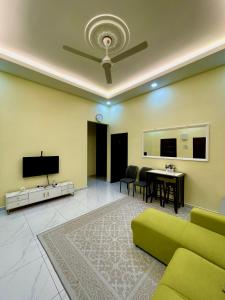 a living room with a green couch and a tv at dayah homestay in Siputih