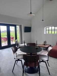 a living room with a table and chairs and a couch at Gastenverblijf spoarsicht in Lioessens