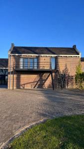 a brick building with a staircase on the side of it at Gastenverblijf spoarsicht in Lioessens