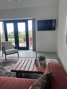 a living room with a wooden coffee table and a television at Gastenverblijf spoarsicht in Lioessens