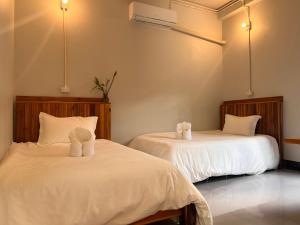 two beds in a room with white sheets at Valley Villa Hotel in Nongkhiaw +21 photos