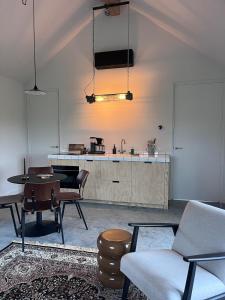 a living room with a table and a kitchen at Gastenverblijf spoarsicht in Lioessens +11 photos