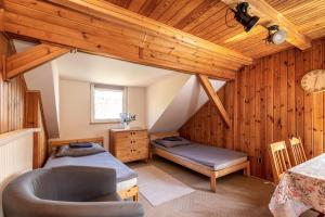 a attic room with two beds and a chair at Nostalgia noclegi in Olsztyn