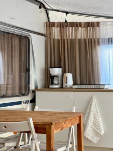 a table and chairs in an rv with a window at Przyczepa kempingowa PannaMontata in Jastarnia