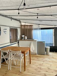 a dining room with a wooden table and chairs at Przyczepa kempingowa PannaMontata in Jastarnia +8 photos