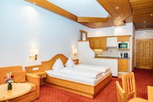 a hotel room with a bed and a table at Appartments Bergland an der Brunnachbahn in Bad Kleinkirchheim