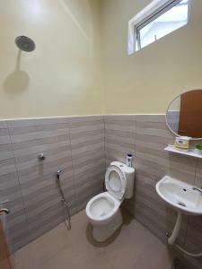 a bathroom with a toilet and a sink at dayah homestay in Siputih +1 photo