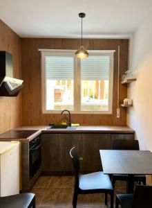 a kitchen with a sink and a table and a window at Beach Studio Apartment in Dhërmi