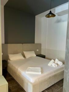 a bedroom with a bed with white sheets and pillows at Beach Studio Apartment in Dhërmi