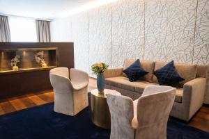a living room with a couch and chairs at Luxury Boutique Hotel Iris Porsche in Mondsee