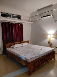 a bed in a room with a red curtain at Homestay in Tezpur