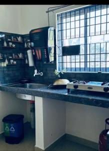 a kitchen counter with a sink and a stove at Homestay in Tezpur