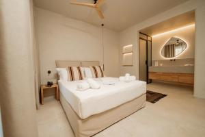 a bedroom with a large white bed and a bathroom at MINT Keramoti in Keramoti