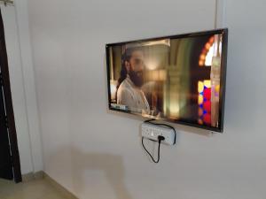 a flat screen tv hanging on a wall at Homestay in Tezpur