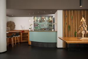 a bar in a restaurant with a counter and a table at Hotel Europa Belluno in Belluno