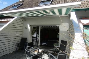 a patio with a table and chairs on it at Pension Altes Posthaus in Dangast