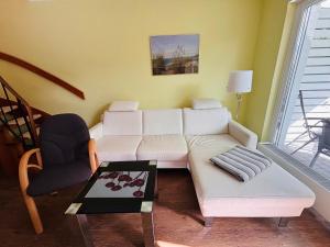 a living room with a white couch and a chair at Pension Altes Posthaus in Dangast
