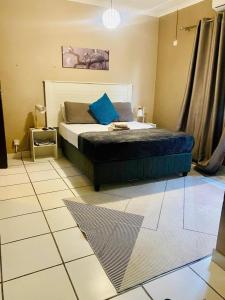 a bedroom with a bed with a blue pillow on it at Maun East Gate Guesthouse in Maun +2 photos