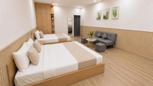 a hotel room with two beds and a couch at Lemon Hotel & Apartment in Danang