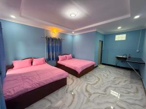 two beds in a room with a large carpet at Mango Bungalow in Kaôh Rŭng (3)