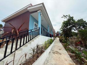 a house with a balcony with a fence at Mango Bungalow in Kaôh Rŭng (3)