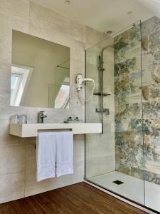 ein Badezimmer mit Dusche, Waschbecken und Spiegel in der Unterkunft Hotel Boutique Aquaria Caneliñas in Portonovo