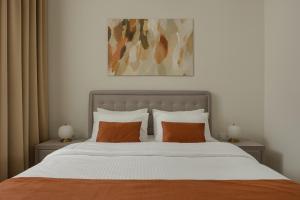 a bedroom with a large bed with orange pillows at Oikia Classic House in Old Town Kavala in Kavála