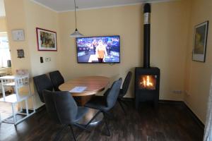 a dining room with a table and a fireplace at Pension Altes Posthaus in Dangast