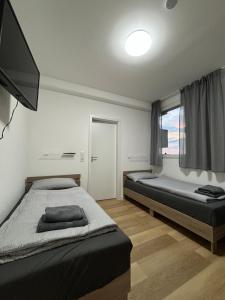 a bedroom with two beds and a flat screen tv at AG Wohnung Fellbach Nr 3 in Fellbach