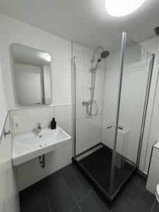 a white bathroom with a shower and a sink at AG Wohnung Fellbach Nr 3 in Fellbach