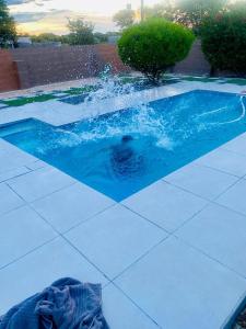 a person swimming in a swimming pool in a swimming pool at Maun East Gate Guesthouse in Maun