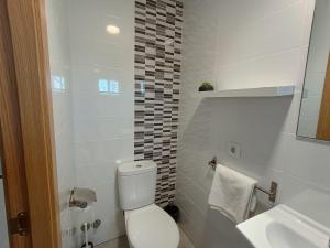 a white bathroom with a toilet and a sink at Pensíon Lucia in Casinos +24 photos