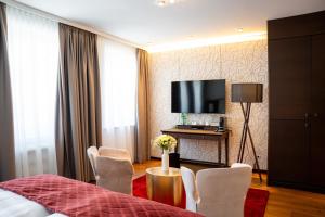 a hotel room with a bed and a television at Luxury Boutique Hotel Iris Porsche in Mondsee