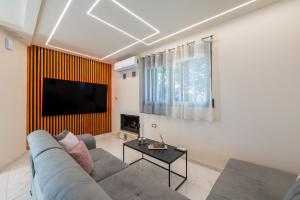 a living room with a couch and a flat screen tv at Angel House in Ialysos