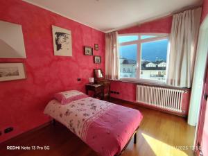 a red bedroom with a bed and a window at La place du Coeur in Pont-Saint-Martin