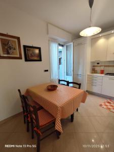 a dining room with a table and chairs and a kitchen at La place du Coeur in Pont-Saint-Martin