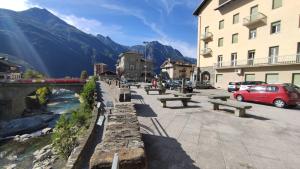 a street with benches and a bridge over a river at La place du Coeur in Pont-Saint-Martin