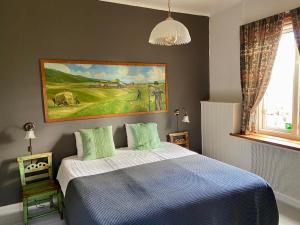 a bedroom with a bed and a painting on the wall at THE LODGE Torsby in Torsby