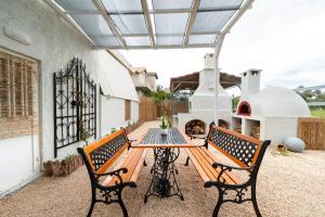a patio with a wooden table and two chairs at Angel House in Ialysos
