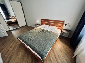 a bedroom with a bed with a green blanket and two mirrors at Spacious 2 bedroom apartment, Old Town Riga in Riga