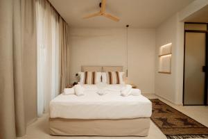 a bedroom with a large white bed with white sheets at MINT Keramoti in Keramoti