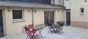 a group of chairs and tables on a patio at Chambre Ecuador in Châteaubourg
