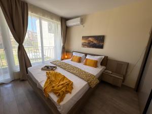 a bedroom with two beds and a large window at Krasi Apartments in Perla Complex in Pomorie