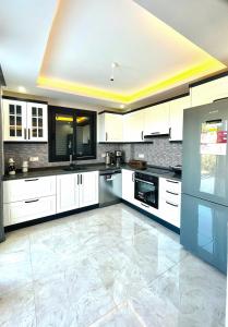 a large white kitchen with white cabinets and appliances at Premium Homes in Didim