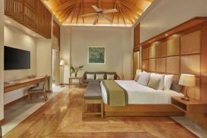 a bedroom with a large bed and a desk at The Farm at San Benito, Autograph Collection in Lipa