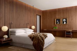 a bedroom with a large white bed and a desk at The London EDITION in London